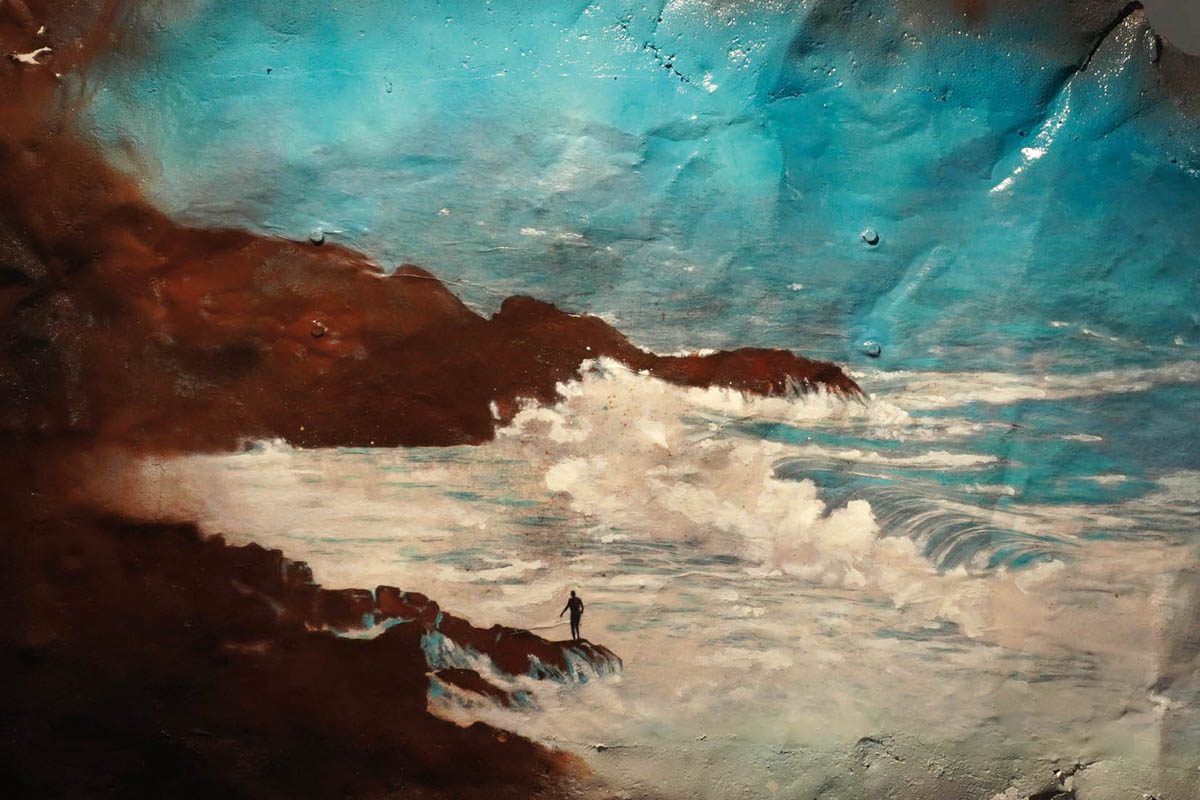 L’homme est la mer. Entre peinture et photo sur une plaque de métal usée et oxydée, découpée comme de la dentelle. A Brest en Bretagne,sous la pluie et la tempête un homme se baigne dans une crique. Une photo prise en noir et blanc, repeinte manuellement aux pastels, crayons de couleurs, peinture sur du métal. Œeuvre à la fois de recyclage et de matière. Le métal fait vibrer le visuel, complète le sujet proposé. Un tableau réalisé par Gaïa du Rivau, photographe, plasticienne, photographiste à Nyons